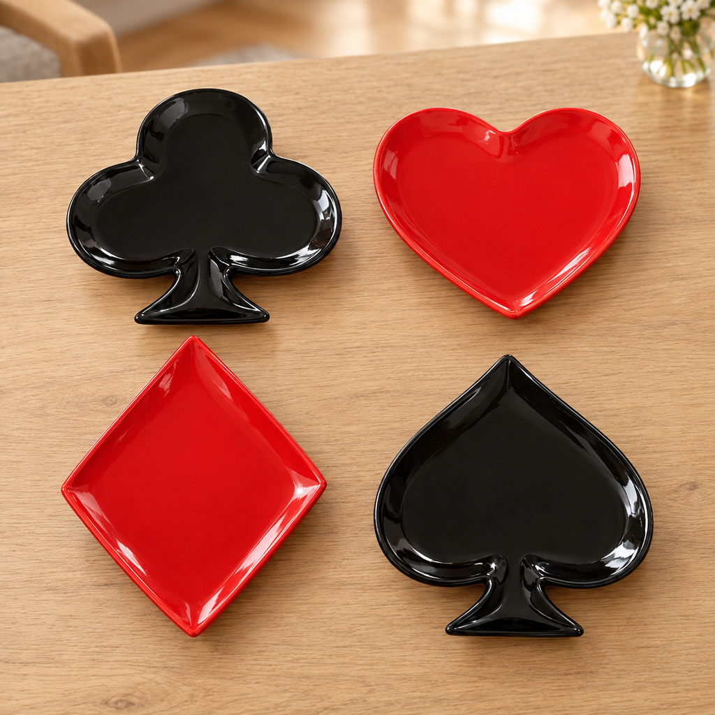 Noche de Cartas: cuatro platos de porcelana con formas de baraja en rojo y negro; ambientación ilustrativa creada con IA